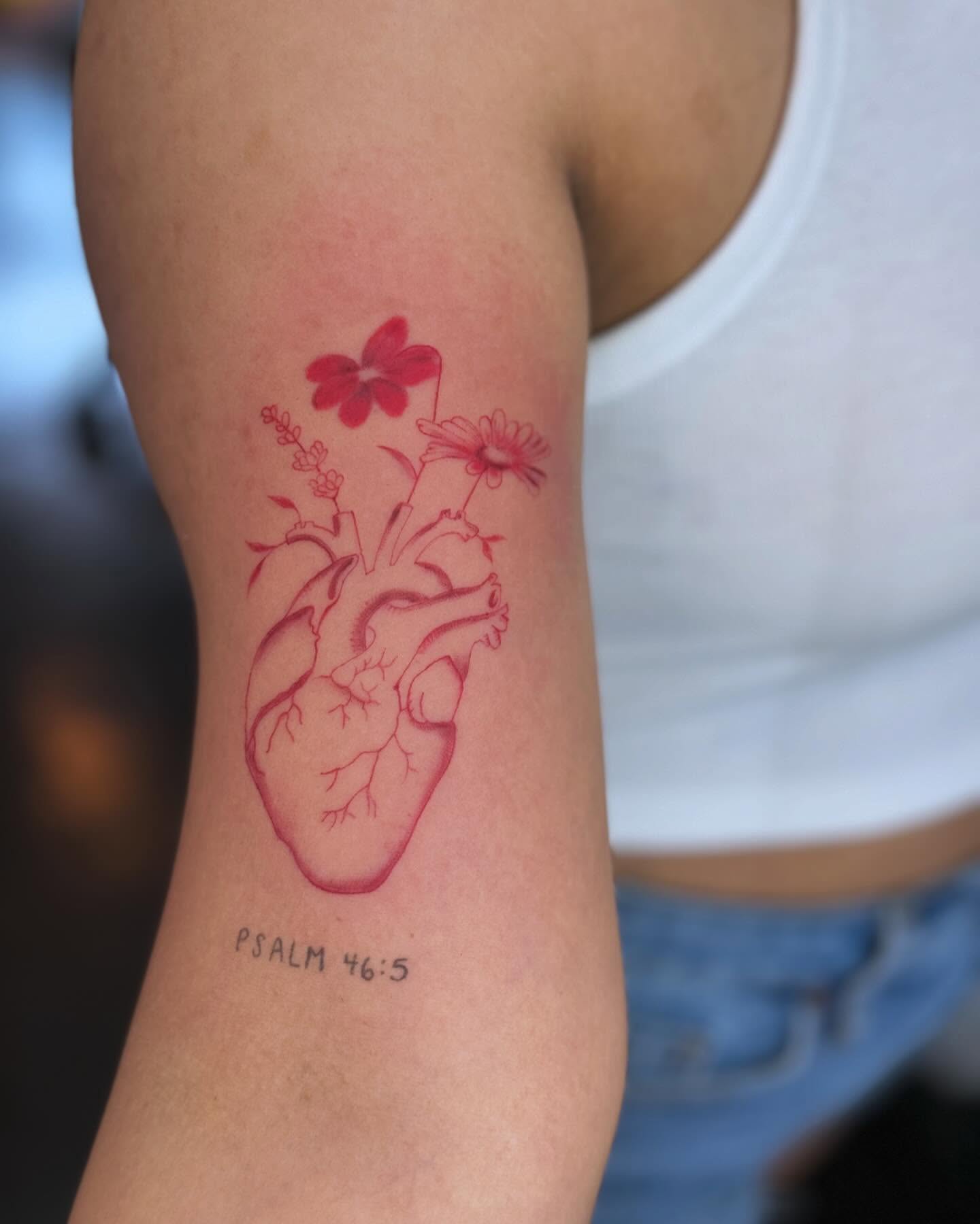 Red anatomical heart tattoo with flowers